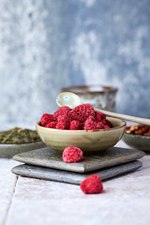 Dried raspberries in a wooden bowl, selective focus.の写真素材