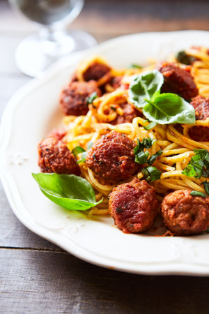 Spaghetti with meatballs, tomato sauce and basil on a plateの写真素材