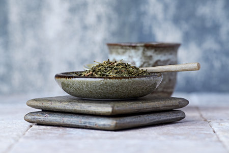Dried herbs in bowls and cups on wooden background. Selective focus.