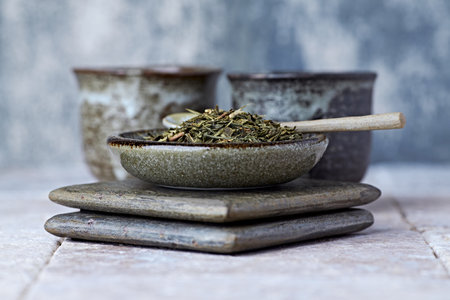 Dried herbs in ceramic bowls on wooden background. Selective focus.