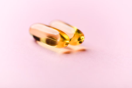 Cod liver oil omega 3 gel capsules on pink background. Fish oil omega 3 gel capsules.の写真素材