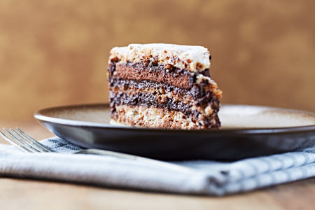 Piece of chocolate cake on a plate on a wooden table.