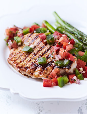 Grilled chicken fillet with asparagus, tomato and onionの写真素材