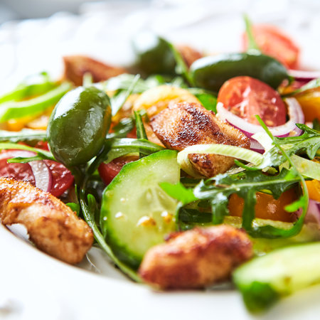 Salad with chicken, arugula, cucumber, tomatoes and olivesの写真素材