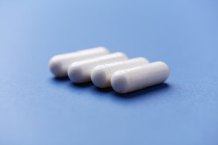 White pills on blue background. Focus on foreground, soft bokeh.