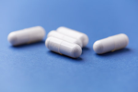 White pills on blue background. Focus on foreground, soft bokeh.