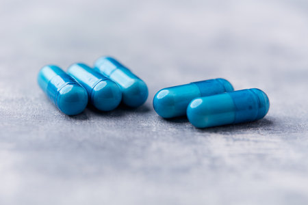 Blue pills on a gray background. Focus on foreground, shallow depth of field.の写真素材