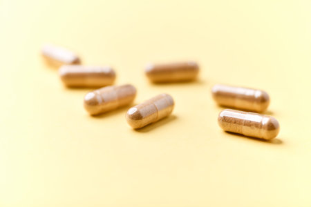 Capsules of dietary supplements on a yellow background. Selective focus.の写真素材