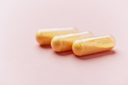 Capsules of omega 3 fish oil on a pink background.