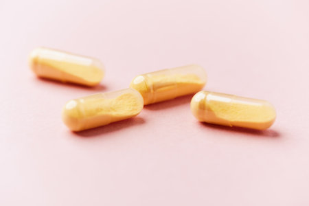 Capsules of omega 3 fish oil on a pink background.の写真素材