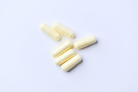 Close up of white capsules on white background. Focus on foreground.の写真素材