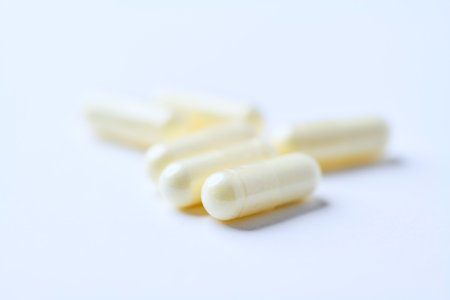 Capsules of white color on a white background. Close-up.