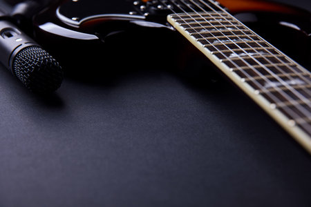 Electric guitar and microphone on a black background. Musical instrument. Close-up.