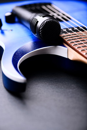Blue electric guitar and microphone on a black background, close-upの写真素材