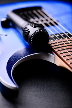 Blue electric guitar and microphone on a black background. Close-up.の写真素材