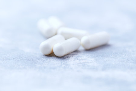 White pills on light background. Focus on foreground, shallow DOF.の写真素材