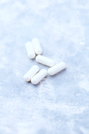 White pills on a light background. Focus on foreground, soft bokeh.の写真素材