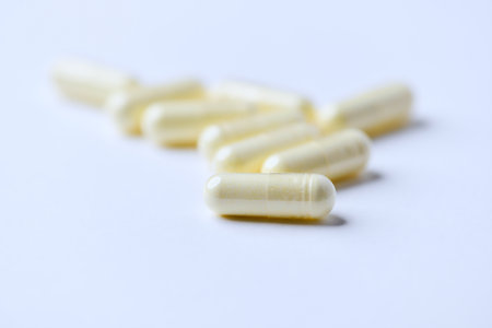 Close up of yellow pills on white background. Focus on foreground.の写真素材