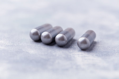 A close up shot of a group of pill capsules on a gray background