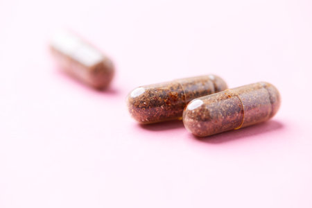 Close up of brown medical pills on pink background with copy space.の写真素材