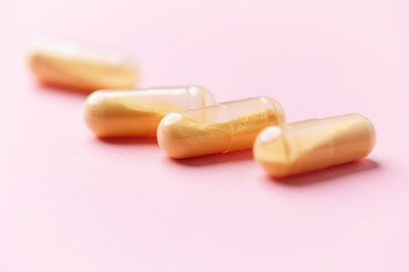 Capsules of yellow color on a pink background. Close up.