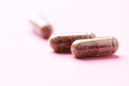 Close up of medicine pills on pink background. Focus on foreground.の写真素材