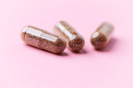 Pills in capsules on a pink background. Close up.の写真素材