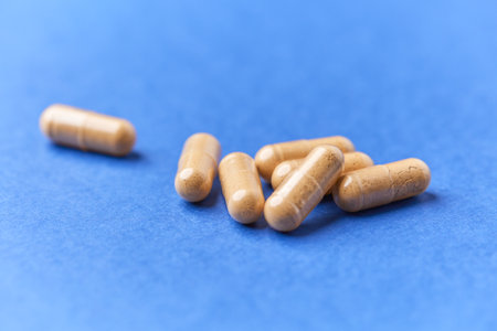 Heap of medical pills on blue background. Close up.の写真素材