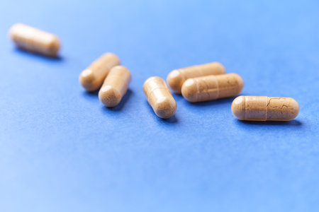Capsule pills on blue background. Focus on foreground, shallow DOF.の写真素材