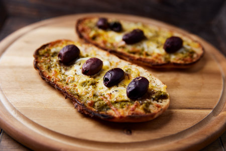 Focaccia with olives and mozzarella on wooden boardの写真素材