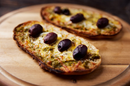 Baguette with mozzarella cheese, olives and basilの写真素材