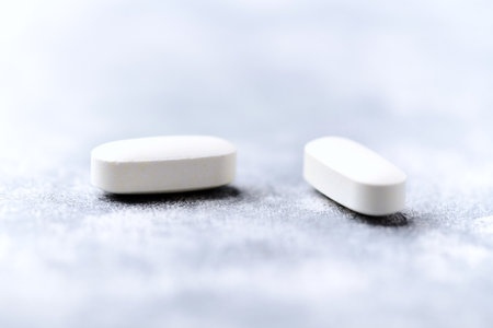 Two white tablets on a gray background. Focus on foreground, shallow depth of field.