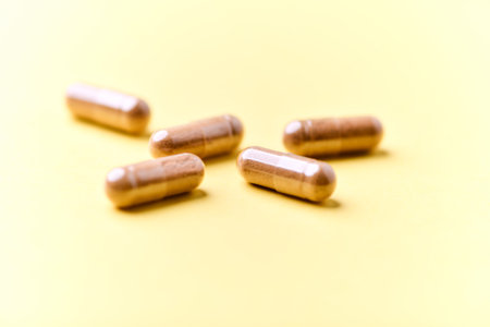Capsules of dietary supplements on a yellow background. Selective focus.
