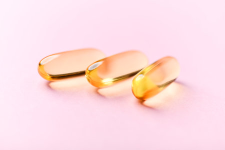 Cod liver oil omega 3 gel capsules on pink background. Fish oil omega 3 gel capsules.