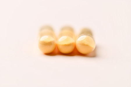 Yellow pills on a white background. Focus on foreground, shallow depth of field.の写真素材
