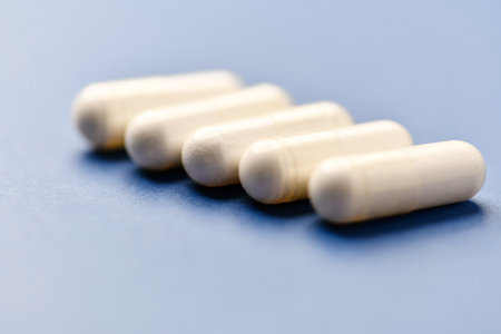 White pills on blue background. Focus on foreground, soft bokeh.