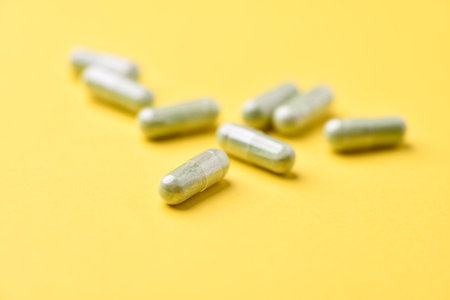 Green capsules on a yellow background. Focus on foreground, shallow DOF.の写真素材