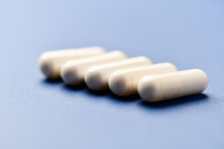 Close-up of white pills on blue background. Focus on foreground.の写真素材