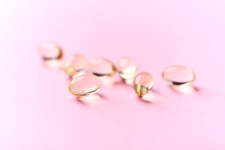 Fish oil capsules on pink background, closeup. Health care conceptの写真素材