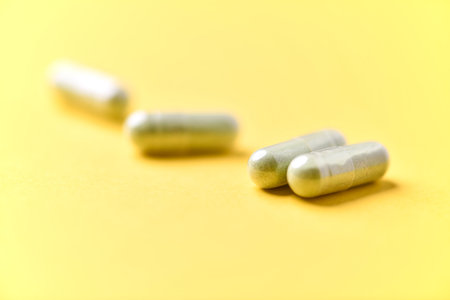 Pills on a yellow background. Focus on foreground, soft bokeh.の写真素材