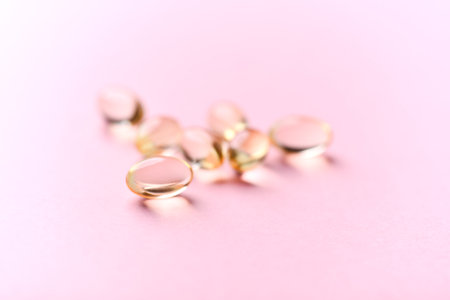 Cod liver oil omega 3 gel capsules on pastel pink background.の写真素材