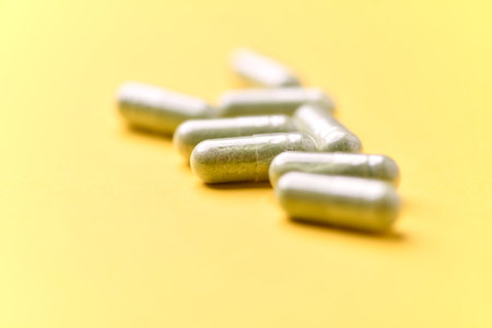 Green capsules on a yellow background. Focus on foreground, shallow DOF.の写真素材