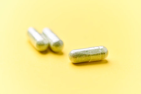 Pills on a yellow background. Focus on foreground, soft bokeh.の写真素材