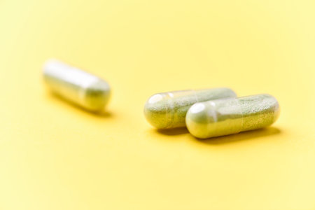 Capsules of medicine on a yellow background. Close up.の写真素材