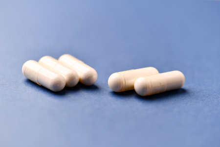 White pills on blue background. Focus on foreground, shallow DOF.の写真素材