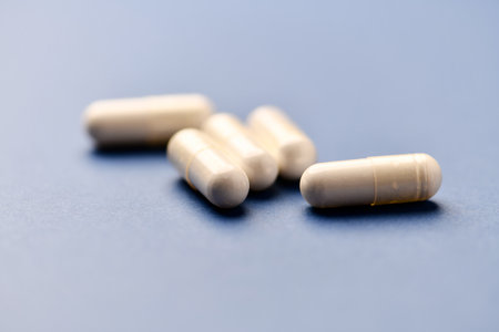 White pills on blue background. Focus on foreground, soft bokeh.の写真素材