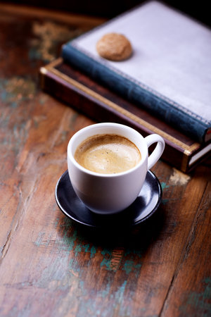 Cup of coffee and book on old wooden table, selective focusの写真素材