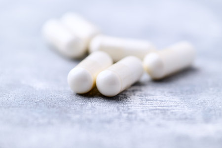 White pills on a gray background. Focus on foreground, shallow depth of field.の写真素材
