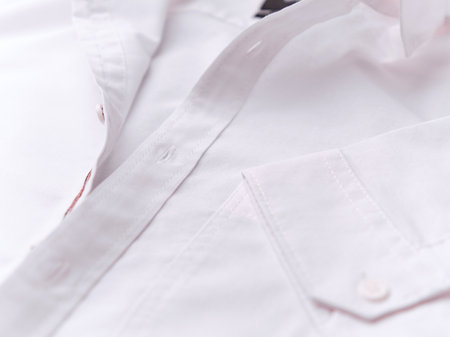 Close-up of a white shirt with buttons on a white backgroundの写真素材