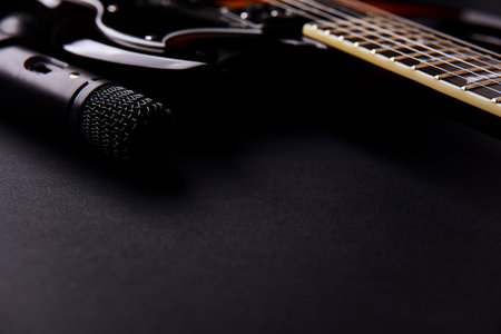 Guitar and microphone on a black background. Close-up.